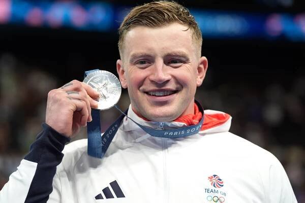 Adam Peaty holding his silver medal from the Men's 100m Breaststroke Final.