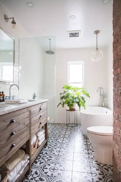 a bathroom with black and white tile flooring next to a bathtub, toilet and sink