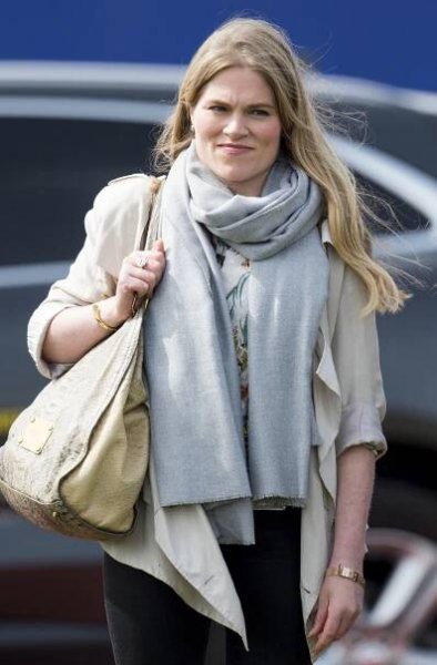a woman wearing a scarf and a louis vuitton purse