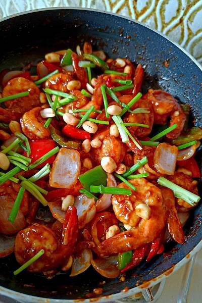Image showing shrimp kung pao in a pan topped with peanuts and scallions.