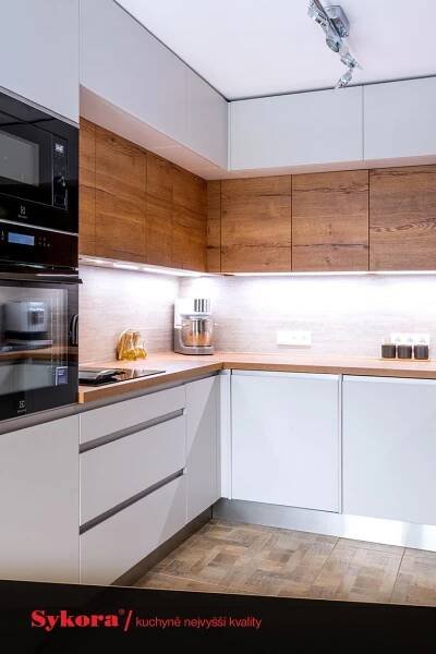 a modern kitchen with white cabinets and wood flooring