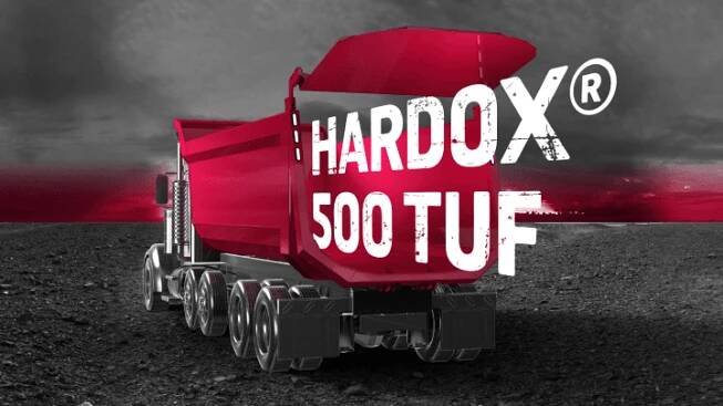 Logo Hardox® 500 Tuf vystupující ze zadní části červené korby nákladního vozu vyrobené z pevné a houževnaté oceli Hardox® 500 Tuf.