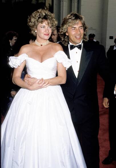 Melanie Griffith in a ballgown and pearls alongside Johnson at theAcademy Awards