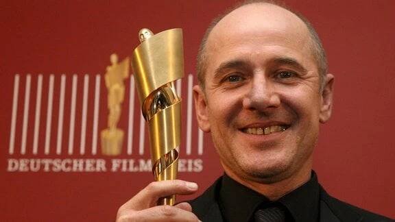 Der Schauspieler Ulrich Mühe hält am Freitag (12.05.06) in Berlin während eines Photocalls zur 56. Verleihung des Deutschen Filmpreises seine Lola in der Hand.
