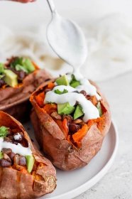 sweet potatoes stuffed with black beans, and avocado and topped with crema