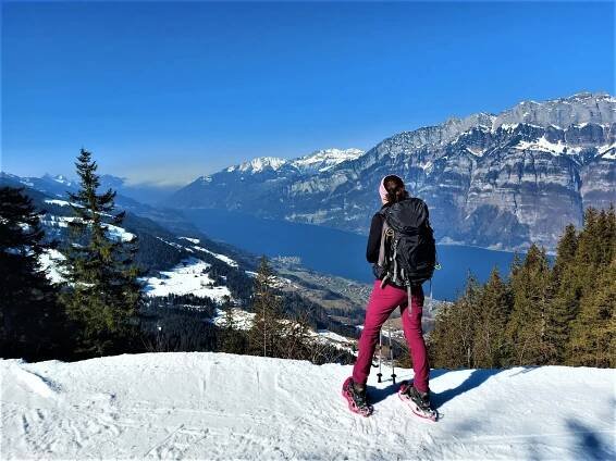 Frau in Schneeschuhen vor Bergpanorama