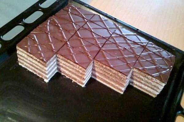 several pieces of chocolate sitting on top of a black tray next to a wooden table