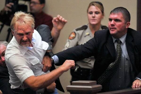 Wesley Thomas, the step father of Tiffany York, is tackled by courtroom security during the hearing of defendant Sgt. Anthony Peden at Long County Superior Court, Thursday Aug. 30, 2012, in Ludowici, Ga. District Attorney Tom Durden announced in court that he will seek the death penalty for Peden, Pvt. Isaac Aguigui, and Pvt. Christopher Salmon. The three Fort Stewart soldiers are accused of malice murder, felony murder and criminal gang activity in the Dec. 4 slayings of former soldier Michael Roark and his girlfriend, 17yearold Tiffany York. The two were found shot to death off a dirt road near the Army post. Prosecutors say the accused men were part of a militia operating within the U.S. Army that was stockpiling weapons and wanted to overthrow the federal government. (AP Photo/Stephen Morton)