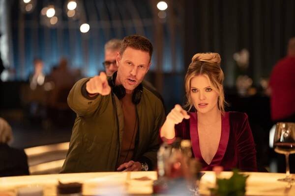 Director Christopher Landon with Meghann Fahy pointing behind the scenes in Drop (2025).
