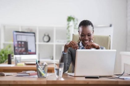 Stáhnout - Pěkná africká obchodní žena pracující na notebooku v kanceláři — Stock obrázek