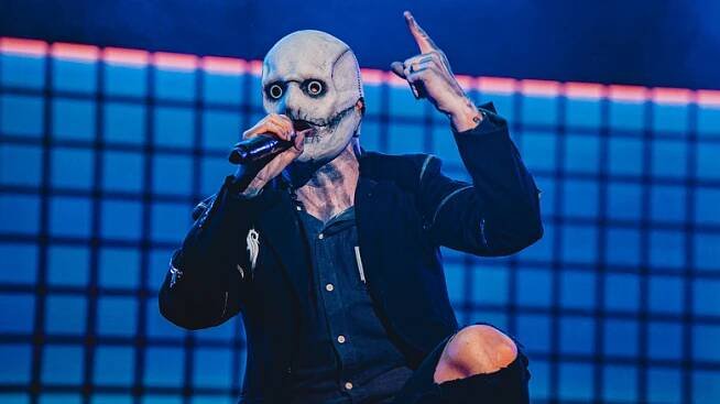 Slipknot's Corey Taylor holding his finger up in the air during a concert