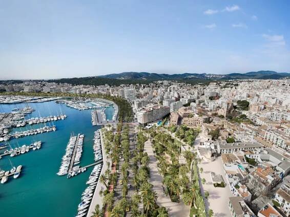 Aerial view of Palma de Mallorca, Spain, featuring a marina filled with boats, a palm-lined promenade, and city buildings.