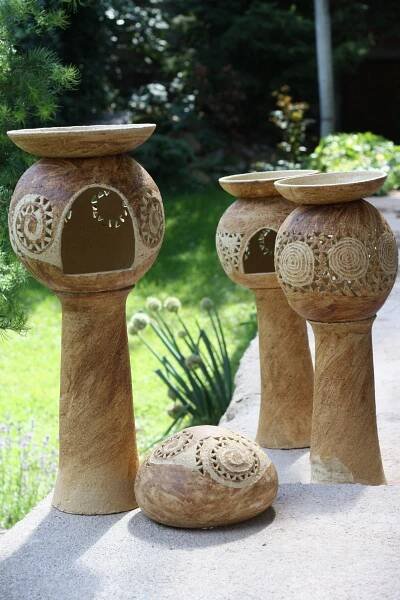 three stone vases sitting on top of a cement slab