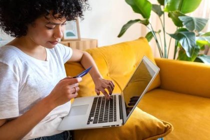 detail afroamerické ženy sedící na gauči pomocí kreditní karty a notebooku k nakupování online z domova. kopírovat prostor. - online nakupování - stock snímky, obrázky a fotky