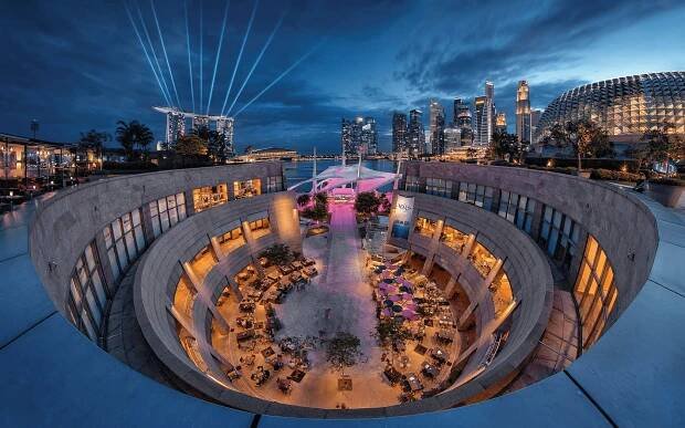 Image of courtyard at Esplanade against the city skyline taken from the Roof Terrace at night.