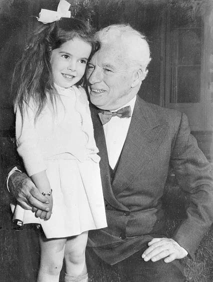 Charles Chaplin accepts a birthday hug from his daughter, Josephine.
