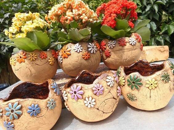 four flower pots sitting on top of a table