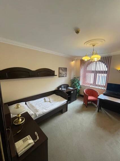 a bedroom with a bed and a desk with a phone at Hotel Bravo in Česká Třebová