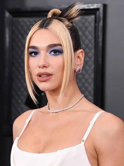 Dua Lipa with porcelain skin and bright blue halo-inspired eyeshadow