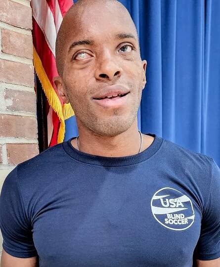 A photo of David Brown wearing a blue USA Blind Soccer t-shirt.