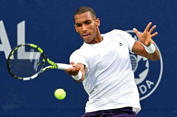 Felix Auger-Aliassime playing tennis.