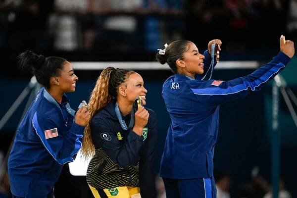 Simone Biles, Rebeca Andrade, and Jordan Chiles take a selfie together at the end of the Women's Floor Exercise Final at the Olympic Games Paris 2024.