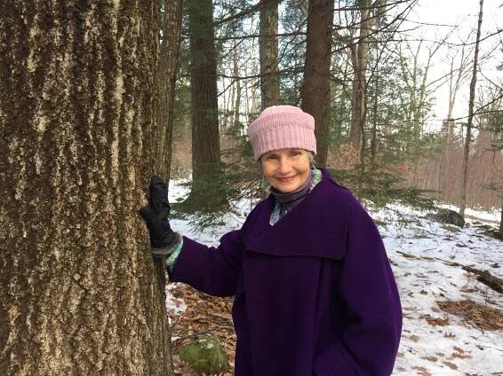 Patricia Lewis standing next to tree on her newly-conserved Westhampton property.