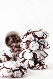 Holiday chocolate cookies in a stack set on a table with a bowl of chocolate chips.