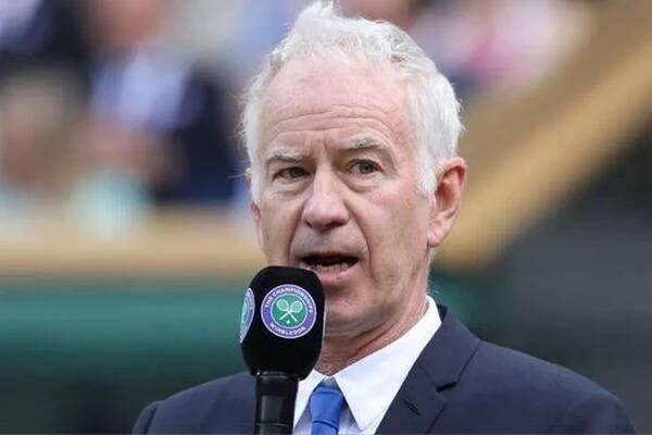 John McEnroe talks into a Wimbledon microphone