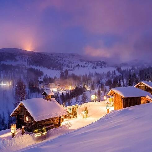 Snow-covered chalets with glowing lights in The Katschberg Advent Trail near Falkensteiner Hotel Cristallo
