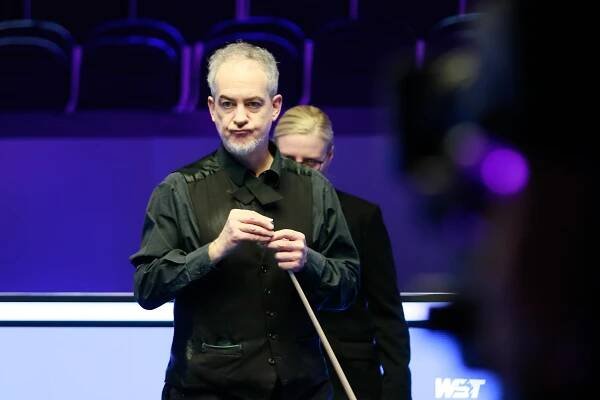 Anthony Hamilton chalking his cue at a snooker match.