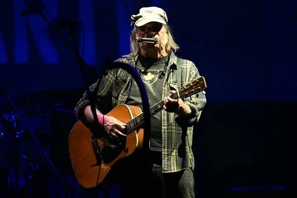 Neil Young playing guitar at a concert.