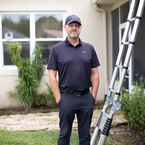 Mike Mitchell, owner of Precision Home and Property Inspections, prepares to climb a ladder outside a residential property.