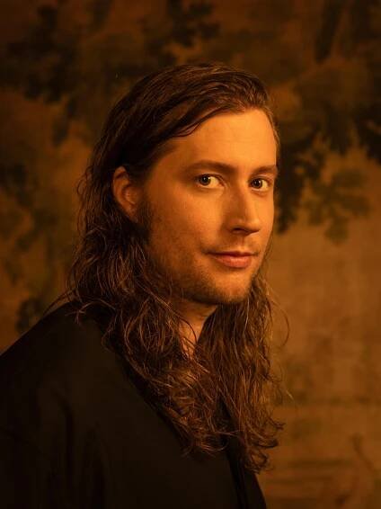 A man with long locks poses for the camera.