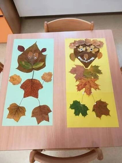 two paper plates with leaves on them sitting on top of a wooden table next to a chair