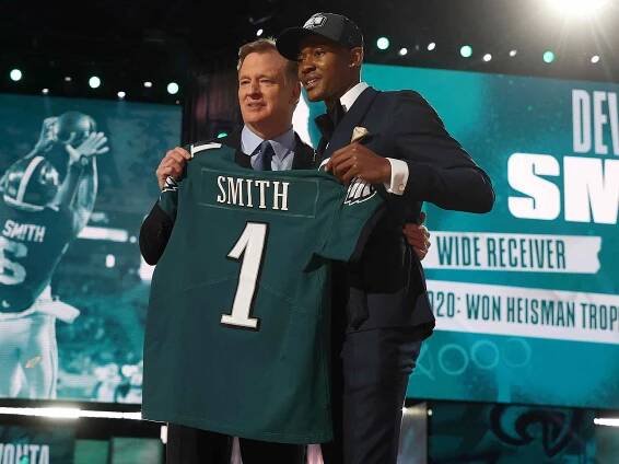 DeVonta Smith poses with NFL Commissioner Roger Goodell onstage after being selected 10th by the Philadelphia Eagles during round one of the 2021 NFL Draft