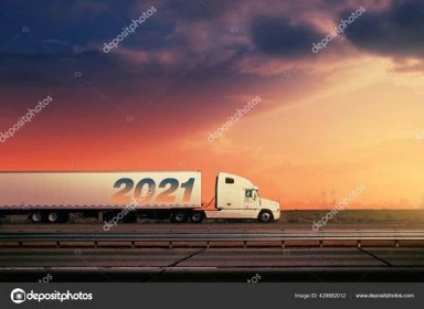 White 2021 Freight Truck Driving Freeway Road Fiery Sunset Sky