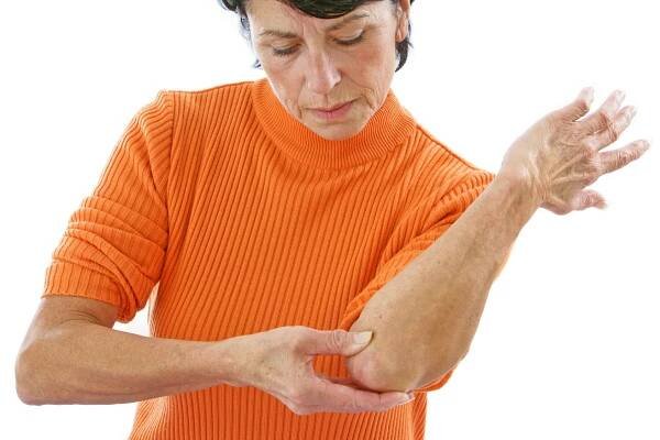 Woman in orange sweater with tendon pain
