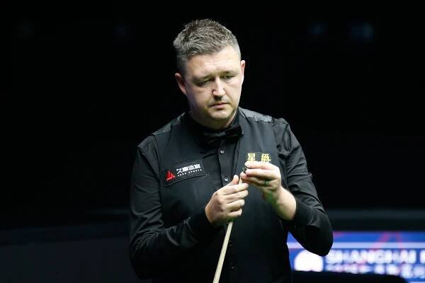 Kyren Wilson chalking his cue.