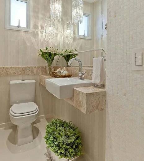 a white toilet sitting next to a sink in a bathroom under a large crystal chandelier