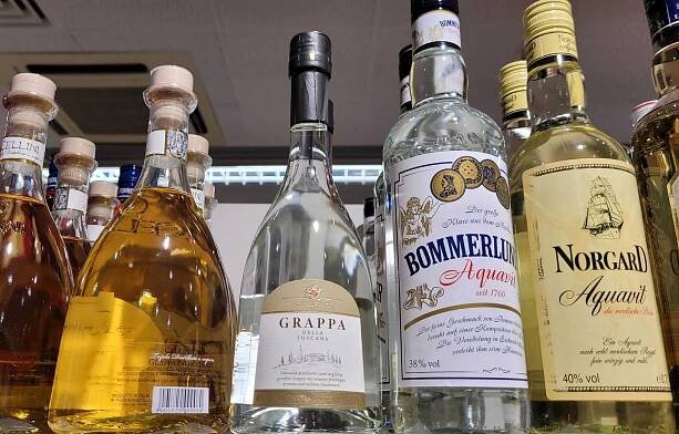 Grappa getestet: eine Flasche Grappa steht neben anderen alkoholischen Getränken in einem Regal.