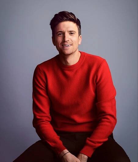 Greg James in a red sweater.