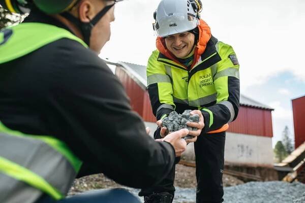 Polar Night Energy CEO Tommi Eronen handles soapstone from Tulikivi CEO Heikki Vauhkonen in Pornainen.
