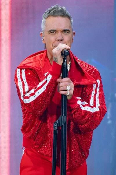 Robbie Williams performing on stage.