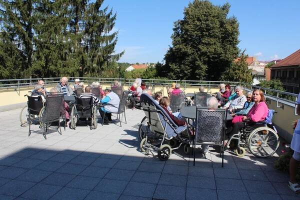 uživatelé sedící na terase, před opékáním špekáčků