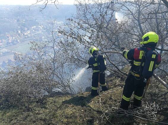 Požár ve skalách nad Vltavou zastavil vlaky i cyklisty. Zasahoval také vrtulník