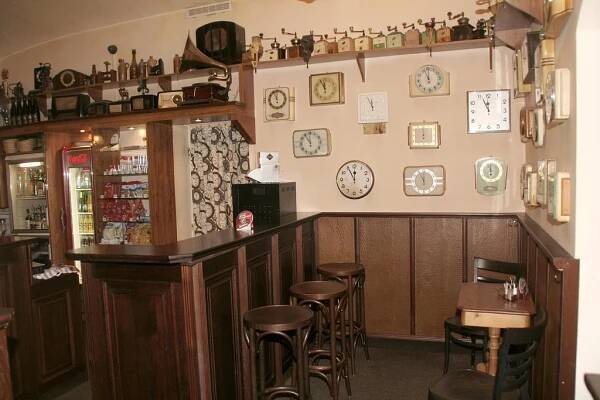 a bar in a restaurant with stools and clocks on the wall at Penzion Aladdin in Teplice