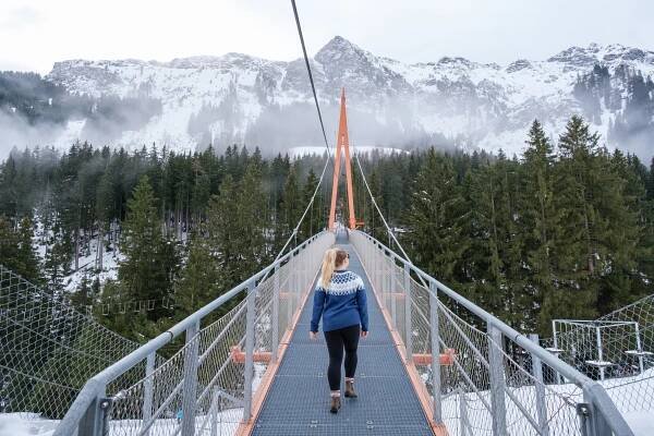 Natasha Walks Across A Bridge In Winter In Austria