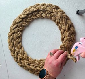 Gluing the ends of the ropes in the braid together before gluing it to the nautical wreath to finish it off.