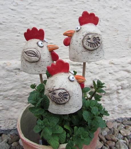 two chicken heads sitting on top of a potted plant